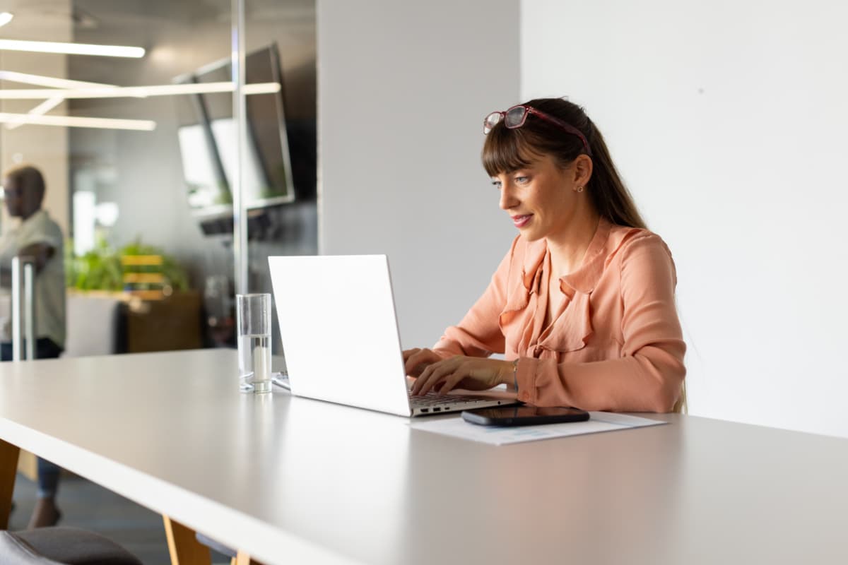 Professionnelle travaillant sur un ordinateur portable dans un espace de bureau moderne